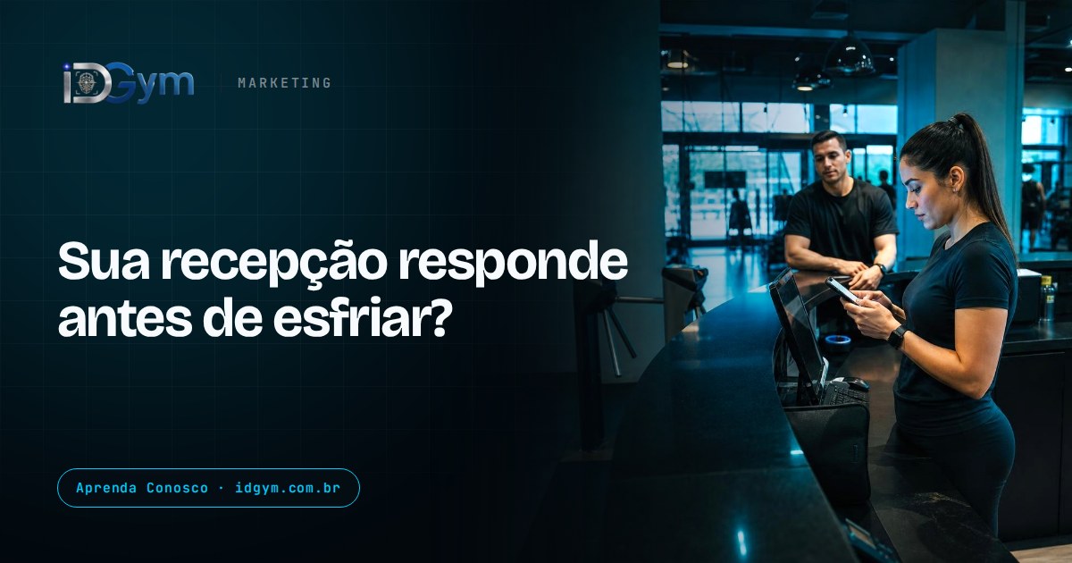 Atendente de recepção em uma academia olhando mensagens no celular perto do balcão, com a entrada e a catraca ao fundo e espaço livre à esquerda.